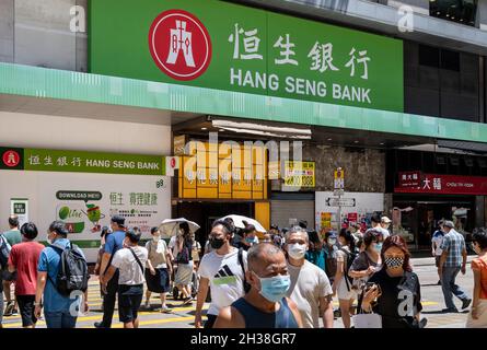 Hongkong, China. Oktober 2021. Fußgänger werden gesehen, wie sie die Straße vor der Hang Seng Bank Filiale in Hongkong überqueren (Foto: Budrul Chukrut/SOPA Images/Sipa USA) Quelle: SIPA USA/Alamy Live News Stockfoto