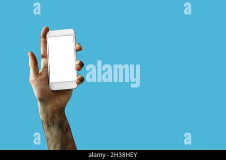 Hand von Zombie mit Handy auf farbigem Hintergrund Stockfoto