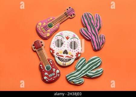 Cookies in Form von Totenkopf, Gitarren und Kakteen auf rotem Hintergrund. El Dia de Muertos Stockfoto