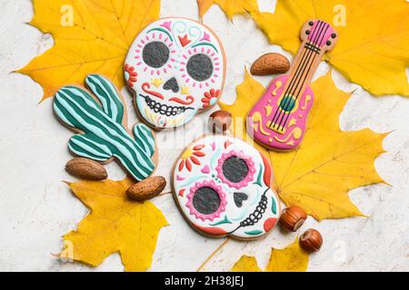 Leckere Kekse für Mexikos Tag der Toten (El Dia de Muertos) mit Nüssen und gefallenen Blättern auf weißem Hintergrund Stockfoto