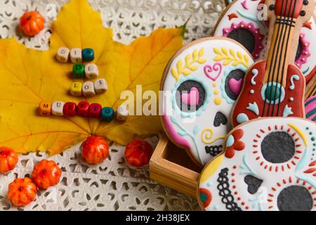 Leckere Kekse für Mexikos Tag der Toten (El Dia de Muertos) und gefallenes Blatt auf Tablett, Nahaufnahme Stockfoto