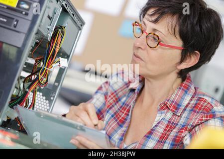 Ausgereifter Ingenieur mit Zwischenablage im Serverraum Stockfoto