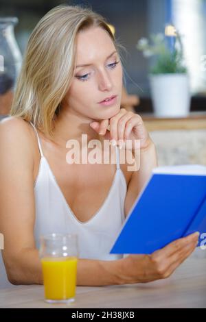 Wunderschöne Frau, die von der Speisekarte im Restaurant bestellte Stockfoto