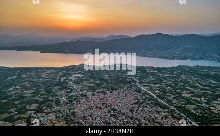 Luftdrohnenblick über den künstlichen See Polyfytos und das Dorf Velventos. Larissa, Griechenland. Stockfoto