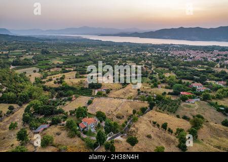 Luftdrohnenblick über den künstlichen See Polyfytos und das Dorf Velventos. Larissa, Griechenland. Stockfoto