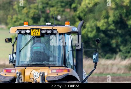 Landwirt, der einen Challenger Agricultural Raupentraktor im Betrieb verwendet, der heiße Abgase aussendet. Stockfoto