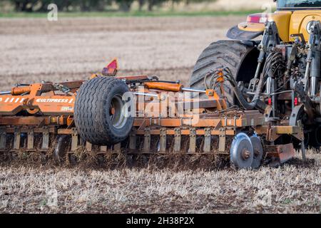 Landwirt, der einen Challenger Agricultural Raupentraktor verwendet und eine 5,5 m Cultipress über ein Feld zieht. Stockfoto