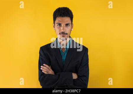 Junger Mann in einem Anzug auf gelbem Grund isoliert. Schöner schwarzer Mann auf Gelb. Stockfoto