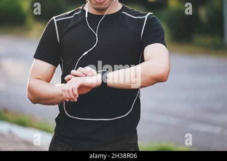 Attraktiver junger Fitnessmann mit Smartwatch. Stockfoto