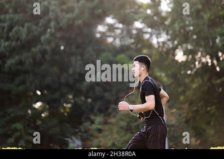 Athletischer junger Mann, der in der Natur läuft. Stockfoto