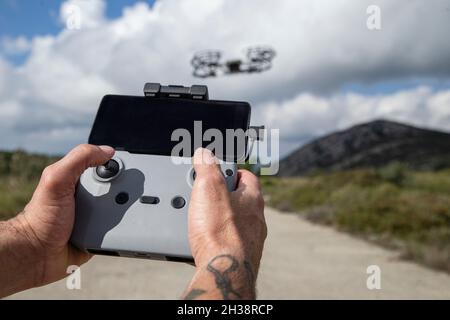 Die Hände des Mannes, der die Fernbedienung der unbemannten Drohne bedient Stockfoto