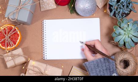 Frau hält kalligraphischen Stift Weihnachten Grußkarte Vorlage in Handwerk Stil. Leeres Papier Nachbau Kalligraphie Stift und Tinte. Kopieren Raum Stockfoto