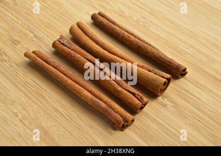 Getrocknete lange braune Zimtstangen, aromatische Würze, auf Holzboden Stockfoto