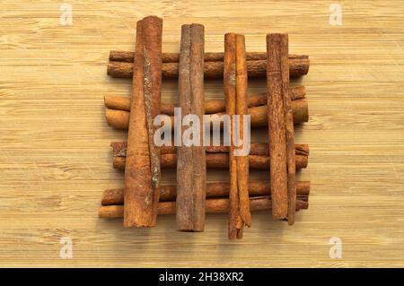 Getrocknete lange braune Zimtstangen, aromatische Würze, auf Holzboden Stockfoto