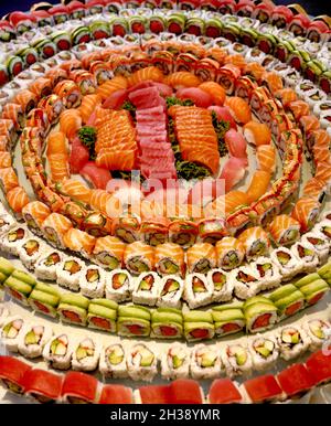 Große Platte mit frischem Sushi und Sashimi bei Veranstaltungen oder Feiern. Kombination von Rollen. Thunfisch, Lachs, Krabben, Avocado, mit weißem Sushi-Reis. Stockfoto