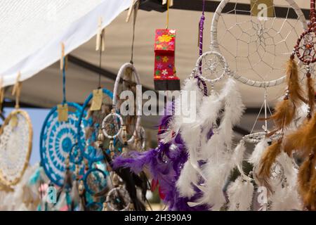 Traumfänger aus Federn hängen im Kiosk auf dem Straßenmarkt. Souvenir, handgemachte originelle Designkonzepte Stockfoto