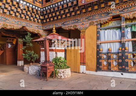 Ein kleiner traditioneller Holzbauchofen aus Metall mit einer Pfeife im Innenhof des Dzong in Bhutan Stockfoto