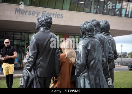 Ein Besucher blickt auf die Bronzestatuen der Beatles am Pier Head, Liverpool Stockfoto