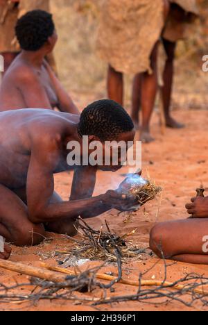 Buschmann, die auf dem primitiven Weg in Grashoek, Namibia, Feuer machen Stockfoto