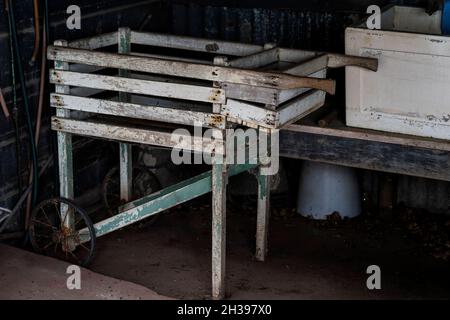 Ein alter Holzwagen zum Ausrollen von gewaschenen Kleidungsstücken bis zur Linie, der in einem alten Schuppen in einem denkmalgeschützten Gehöft aufbewahrt wird Stockfoto