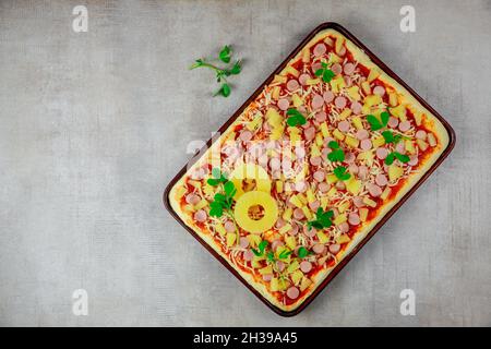Blick von oben auf hausgemachte Ananas, Käse und Wurst Pizza in der Pfanne. Stockfoto
