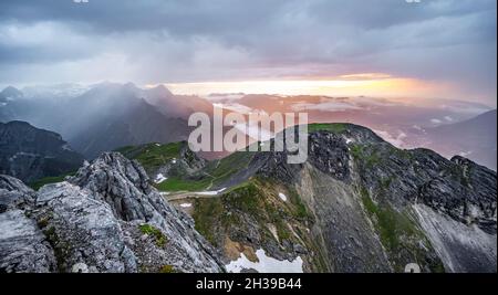 Sonnenuntergang vom Gipfel, westliche Toerlspitze, Berge in dramatischen Wolken, Zugspitze links, Wettersteingebirge, Garmisch-Partenkirchen Stockfoto