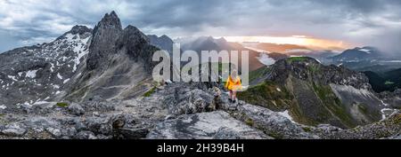 Wanderer, Sonnenuntergang von einem Gipfel, westliche Toerlspitze, Berge mit dramatischen Wolken, links Partenkirchner Dreitorspitze, Wettersteingebirge Stockfoto