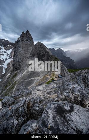 Berge in dramatischen Wolken, Blick vom Gipfel der Westlichen Toerlspitze, hinter Partenkirchner Dreiterspitze, Wettersteingebirge Stockfoto