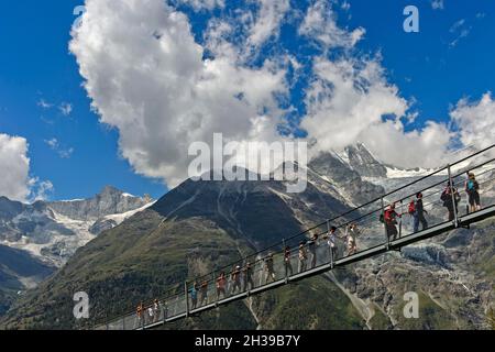 Wanderer überqueren die Charles Kuonen Hängebrücke, die längste Fußgängerhängebrücke der Alpen, Randa, Wallis, Schweiz Stockfoto