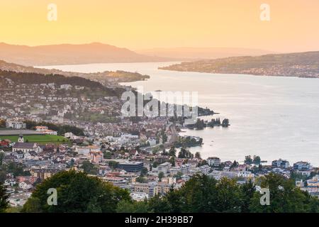 Blick bei Sonnenuntergang vom Feusisberg über den Zürichsee nach Zürich, mit Wollerau, Richterswil, Waedenswil und Meilen und dem Uetliberg im Hintergrund Stockfoto