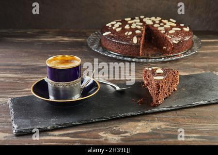 Herbstlicher Brownie-Kuchen mit Walnüssen und Schokolade. Tasse Kaffee auf dem Hintergrund. Französische Gourmetküche Stockfoto