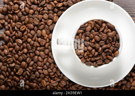 Weißer Kaffeebecher gefüllt mit Kaffeebohnen Stockfoto