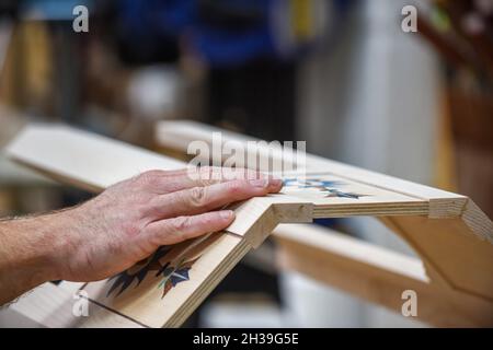 Mann mit Fertigprodukt, das er als Tischler in Arbeit gemacht hat Stockfoto