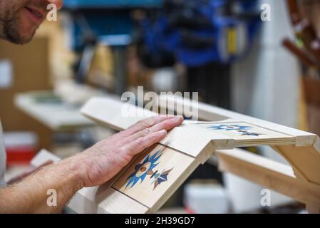 Mann mit Fertigprodukt, das er als Tischler in Arbeit gemacht hat Stockfoto