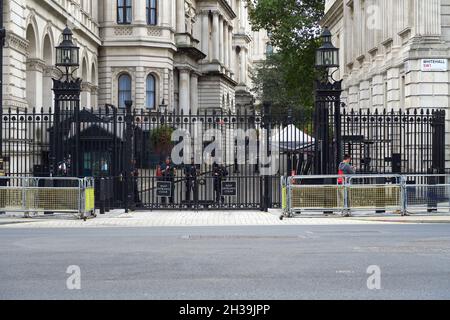 Bewaffnete Polizisten bewachen den Eingang zur Downing Street, Whitehall, London, das srteet beherbergt die offizielle Residenz des Premierministers von Großbritannien Stockfoto