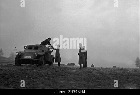 Offizier auf dem Truppenübungsplatz eine Komposition des Typen Panzerspähwagen Sd.Kfz.221, Deutschland 1930er Jahre. Ein Offizier in einem miltary Training Boden mit einer gepanzerten Scout Car, Deutschland 1930. Stockfoto