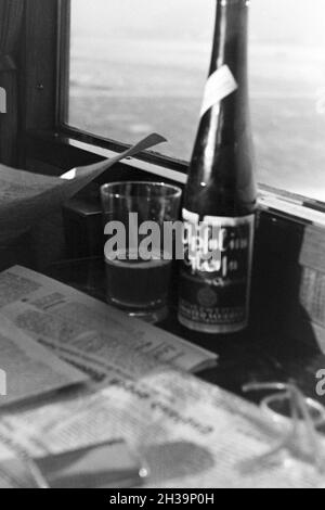 Eine Flasche 'Apfel' im Glas Apfelsaft, Deutschland 1930er Jahre. Eine Flasche und ein Glas Apfelsaft, Deutschland 1930. Stockfoto