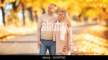 Ein verliebter Erwachsener auf einem Spaziergang in der goldenen Herbstallee. Stockfoto