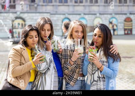 Antwerpen, Belgien, 21. Mai 2021, Muti Ethnische Gruppe von Freundinnen, die Spaß haben, Cocktails im Freien in der Stadt im Bar-Restaurant zu trinken. Hochwertige Fotos Stockfoto