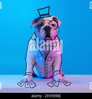 Zeitgenössische Kunstwerke. Ein netter, witziger Hund wie ein Gentleman im Casino, isoliert auf blauem Studiohintergrund in Neon mit Zeichnungen. Stockfoto