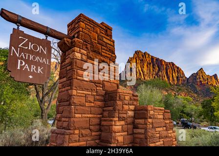 Dies ist ein Blick auf das Schild am begehbaren Eingang zum Zion National Park, Springdale, Washington County, Utah, USA. Der Wächter ist in der Ferne. Stockfoto