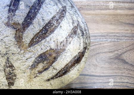Nahaufnahme von Sauerteig-Roggenbrot auf Holztisch, Hintergrund Stockfoto