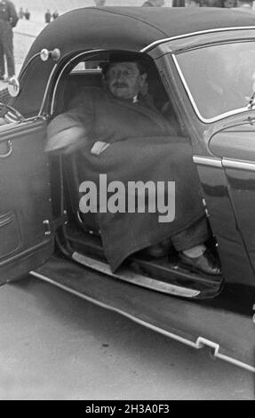 Der deutsche Ingenieur Ferdinand Porsche bei der Abfahrt von der AVUS Rennstrecke in Berlin, Deutschland 1930er Jahre. Der deutsche Ingenieur und Erfinder Ferdinand Porsche verlässt die Berliner AVUS-Rennstrecke in den 1930er Jahren. Stockfoto