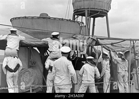 Matrosen bei der Arbeit auf Deck des Schiffs im Hafen Usedom an der Ostsee, Deutschland 1930er Jahre. Segler an Deck eines Schiffes im Usedom Hafen an der Ostsee, Deutschland 1930. Stockfoto