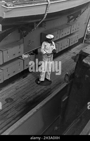 Matrose des Artillerie Schulbootes 'Fuchs' bei seiner Arbeit am Schiff und ein Deck im Hafen von Usedom an der Ostsee, Deutschland 1930er Jahre. Sailor der Artillerie Bildung Boot 'Fuchs' auf dem Schiff und auf dem Deck auf Usedom Hafen an der Ostsee, Deutschland 1930. Stockfoto