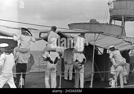 Matrosen bei der Arbeit auf Deck des Schiffs im Hafen Usedom an der Ostsee, Deutschland 1930er Jahre. Segler an Deck eines Schiffes im Usedom Hafen an der Ostsee, Deutschland 1930. Stockfoto