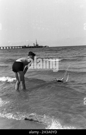 Ein Junge mit seinem spielzeugboot im Urlaub an der Ostsee, Deutschland 1930er Jahre. Ein Junge mit seinem Spielzeug Boot an der Ostsee, Deutschland 1930. Stockfoto