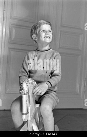 Ein kleiner Junge auf seinem Schaukelpferd, Deutschland 1930er Jahre. Ein kleiner Junge auf seinem Schaukelpferd, Deutschland 1930. Stockfoto