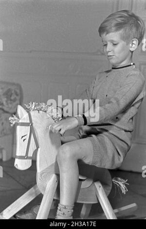 Ein kleiner Junge auf seinem Schaukelpferd, Deutschland 1930er Jahre. Ein kleiner Junge auf seinem Schaukelpferd, Deutschland 1930. Stockfoto