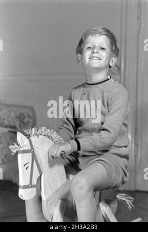 Ein kleiner Junge auf seinem Schaukelpferd, Deutschland 1930er Jahre. Ein kleiner Junge auf seinem Schaukelpferd, Deutschland 1930. Stockfoto